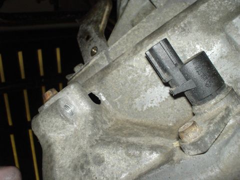 1995 Ford Probe - A close-up view of an automotive transmission housing and sensor.