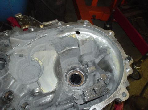 1995 Ford Probe - Close-up of a damaged transmission casing, showing a hole and a bearing.