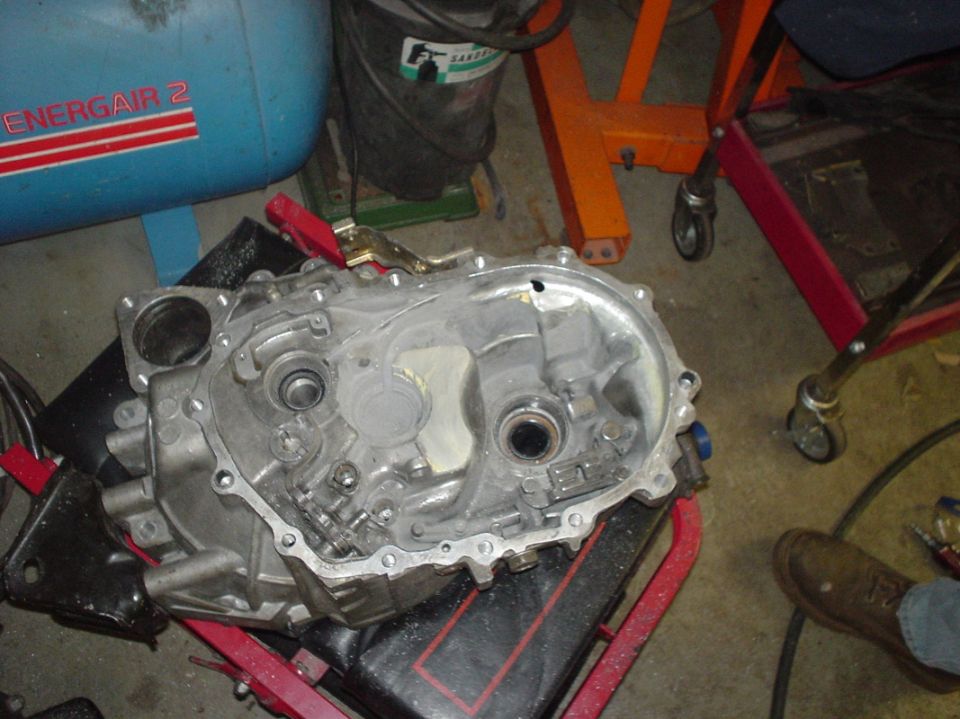 Transmission casing with internal components visible, resting on a stand