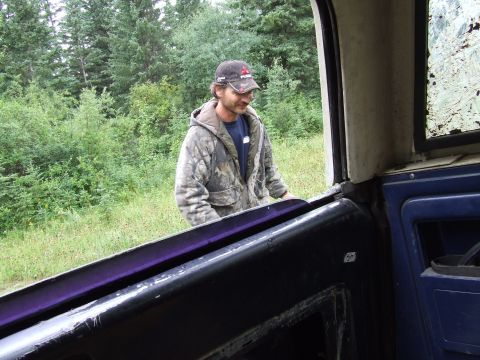 1988 Ford Bronco - A man stands next to an open vehicle door in a wooded area.