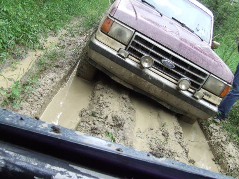 1988 Ford Bronco - This 1988 Ford Bronco is stuck in a muddy ditch, with its front tires deep in the mire.