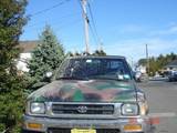 1992 Toyota Tacoma - A camouflaged Toyota pickup truck is seen from the front on a sunny day.