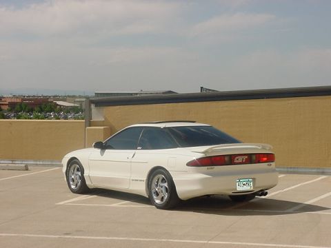 1996 Ford Probe - The rear of a white 1996 Ford Probe GT is visible in a parking lot.
