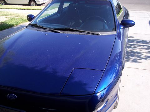 1995 Ford Probe - A blue Ford Probe is parked in a driveway, with a white car in the background.
