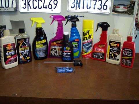 1995 Ford Probe - Various car cleaning products are arranged on a table, with license plates and a small car photo in the background.
