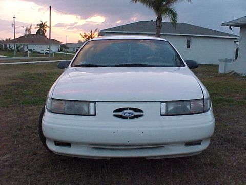 1994 Ford Taurus - White 1994 Ford Taurus front view, parked in a residential area at dusk.