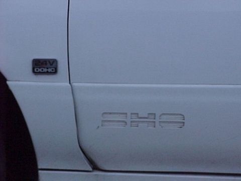 1994 Ford Taurus - The side of a 1994 Ford Taurus SHO is shown, the 'SHO' emblem and a '24V DOHC' badge.