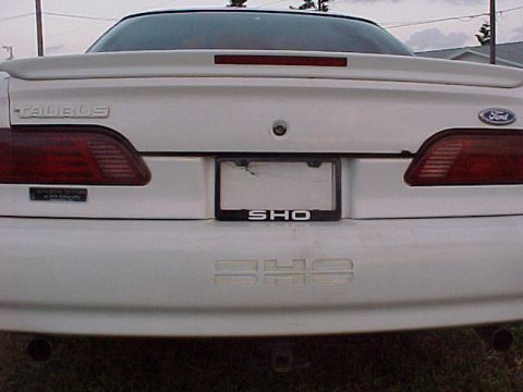 1994 Ford Taurus - Rear view of a white Ford Taurus SHO, identifiable by its distinctive badging and taillights.