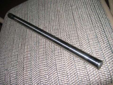 1985 Ford Bronco - A metal rod rests on a textured fabric seat, with a website watermark visible in the lower right corner.
