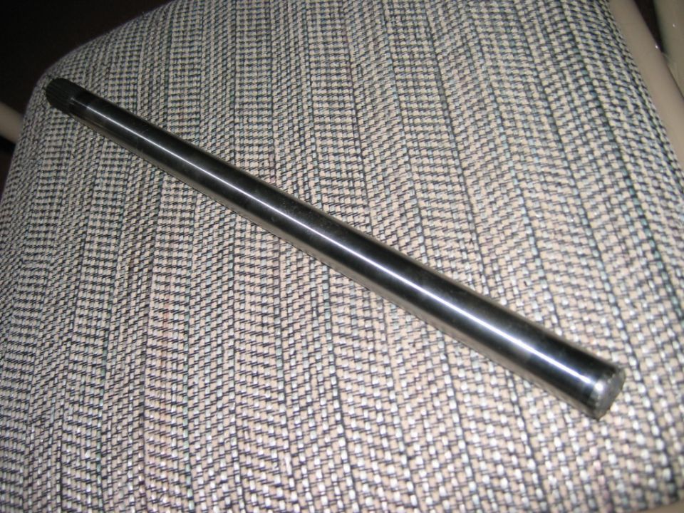 Splined metal shaft or axle rod resting on patterned upholstery
