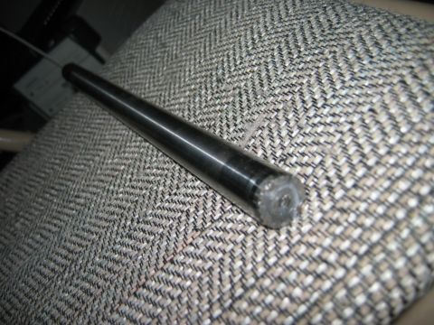 1985 Ford Bronco - A close-up view of a metal rod resting on a textured fabric surface.