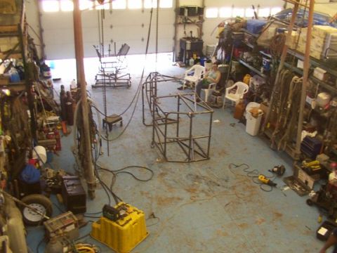 1978 Ford Bronco - A workshop scene shows a custom metal frame being built, surrounded by tools and storage.