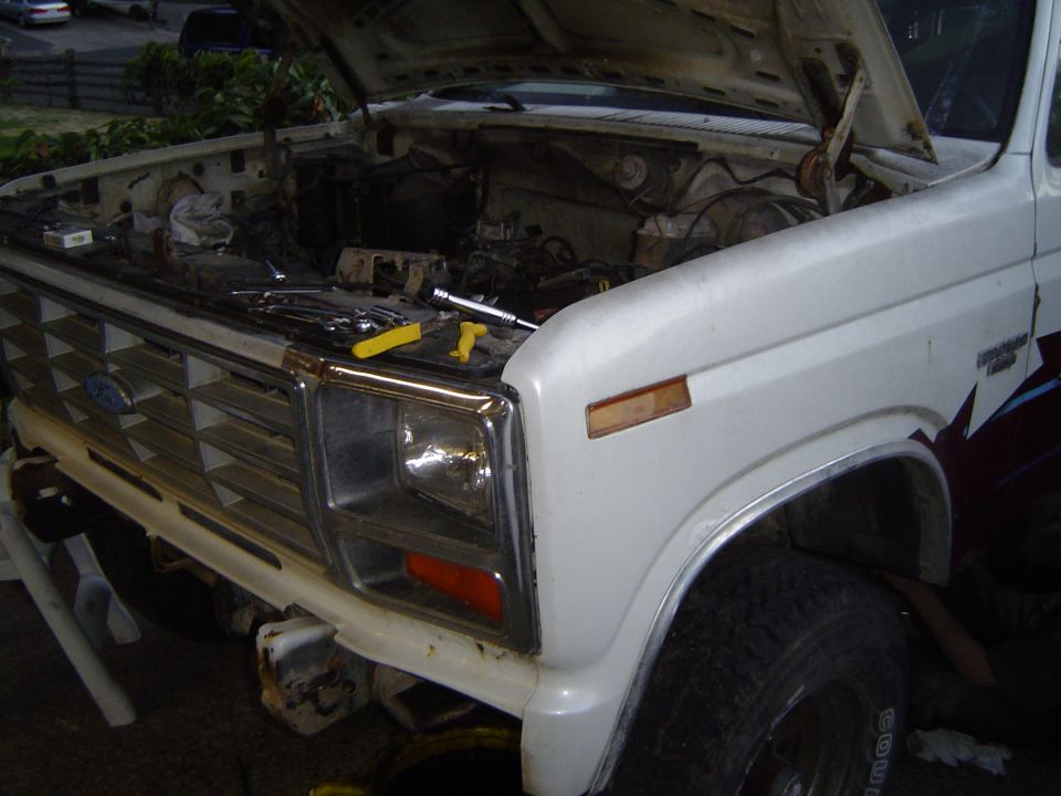 Ford truck with hood open, tools on engine, front end visible