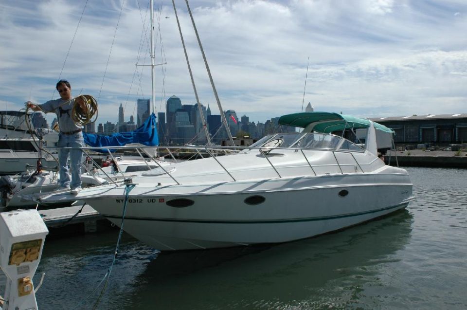 Man on a docked boat with city skyline in background