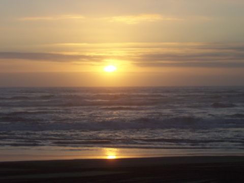 1994 Ford F-150 - A tranquil sunset scene over the ocean, with waves gently rolling onto the shore.
