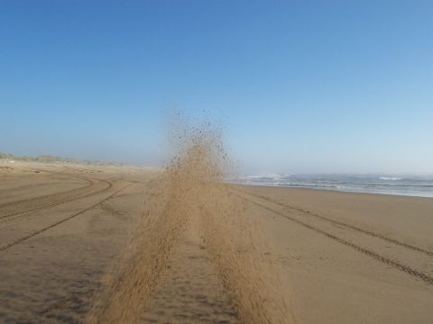 1994 Ford F-150 - Tire tracks mark the sandy shore of a beach under a clear blue sky.