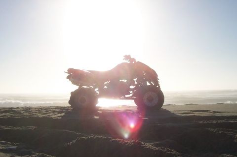 1994 Ford F-150 - A quad bike sits on a sand dune overlooking the ocean as the sun shines brightly.