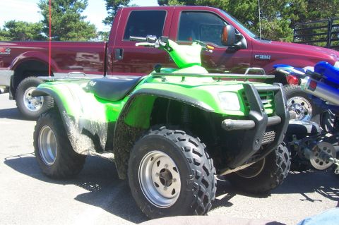 1994 Ford F-150 - Green ATV and a red Ford F-350 truck are parked outdoors. The F-350 badge is visible.
