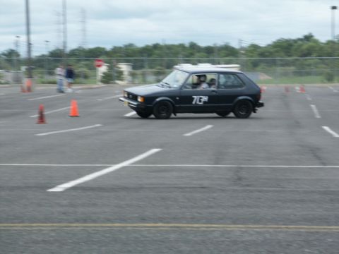 2001 Mercury Grand Marquis - A black hatchback with the number 73 on its door navigates a course marked by orange cones.