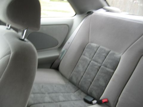 1995 Ford Thunderbird - Interior view of gray cloth rear seats and headrest, showing the seatbelt mechanism.