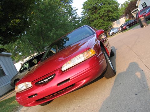 1995 Ford Thunderbird - A red 1995 Ford Thunderbird coupe is parked on a residential street.