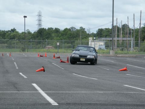 2001 Mercury Grand Marquis - A dark coupe with a hood scoop is seen on a cone course in an asphalt lot.