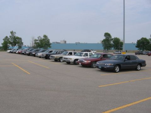 1988 Mercury Grand Marquis - A row of sedans, including a dark blue 1998 Mercury Grand Marquis, are parked in an outdoor lot.