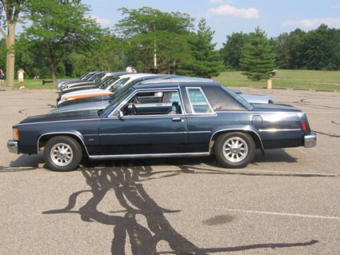1988 Mercury Grand Marquis - Side view of a 1988 Mercury Grand Marquis coupe in a parking lot with other vehicles.