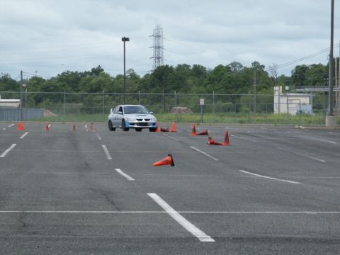 2001 Mercury Grand Marquis - Silver Mitsubishi Lancer Evolution IX navigates a cone course in an open parking lot.