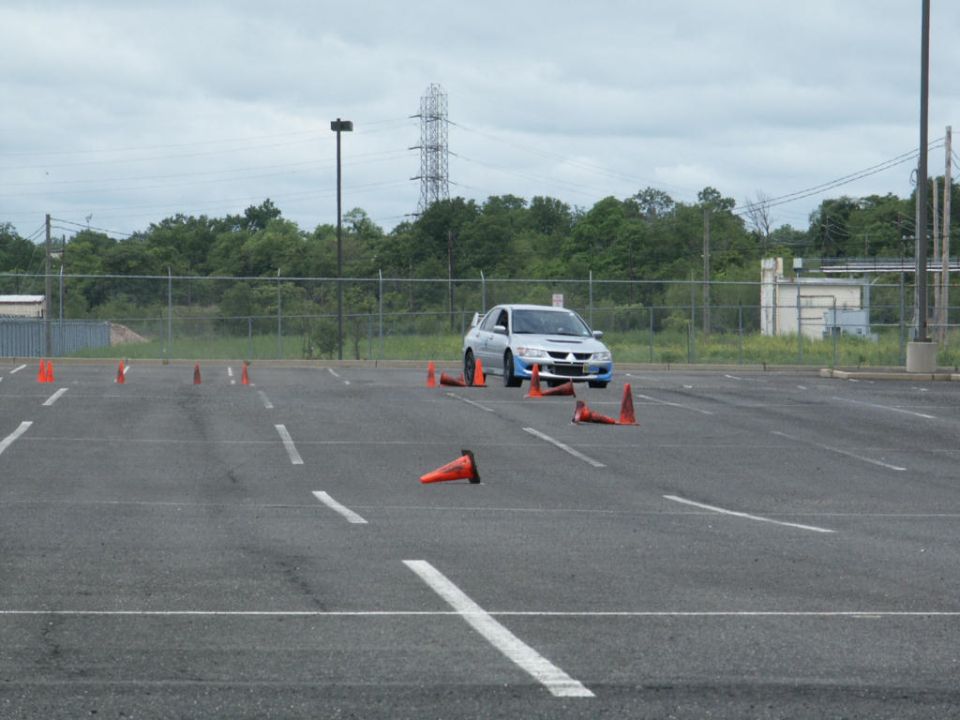 Silver sedan with spoiler on cone course