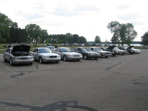 1988 Mercury Grand Marquis - A line of Mercury Grand Marquis sedans are parked in an outdoor lot under a cloudy sky.
