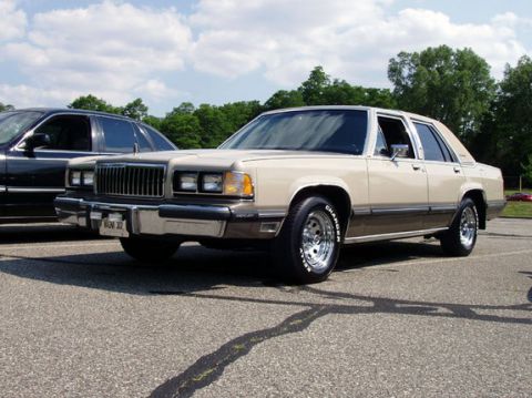 1988 Mercury Grand Marquis - Cream and brown 1988 Mercury Grand Marquis sedan with chrome wheels.