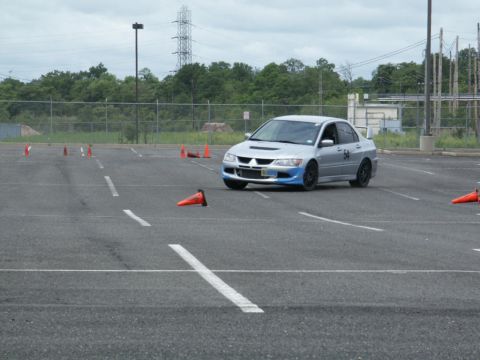 2001 Mercury Grand Marquis - Silver sedan with blue front accents and spoiler navigates a cone course, likely during a timed event.