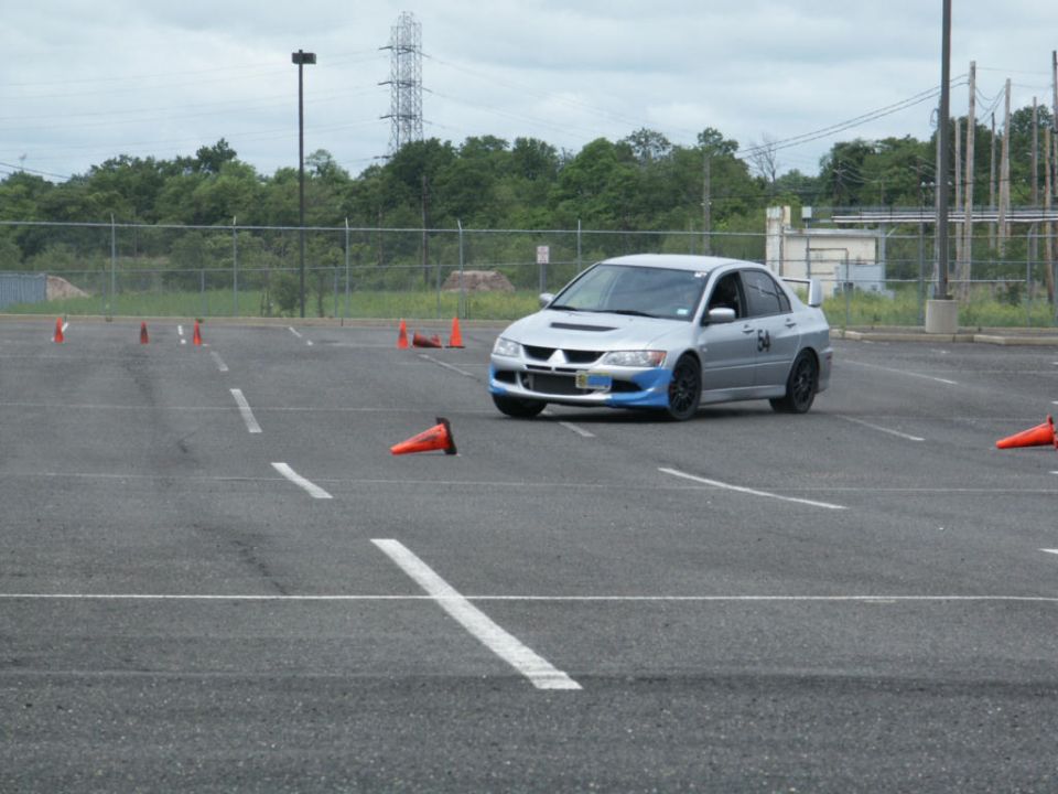 Silver sedan with blue front accents and spoiler on a race course with cones