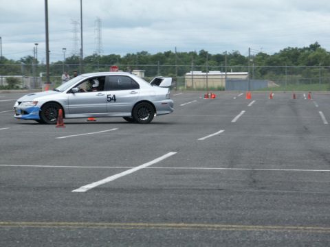 2001 Mercury Grand Marquis - Silver sedan navigates a course marked by orange cones on a cloudy day.
