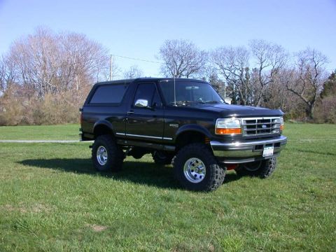 1996 Ford Bronco - This 1996 Ford Bronco is shown from a 3/4 front angle, parked outdoors on a grassy field.