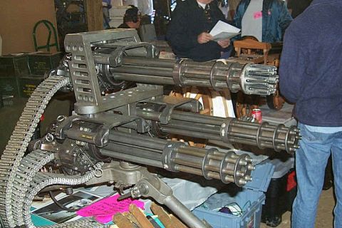 1995 Ford Bronco - A close-up view of a M134 Minigun, a rotary machine gun, is displayed indoors with people observing.