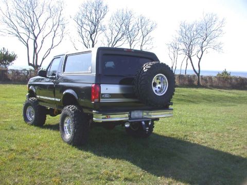 1996 Ford Bronco - This black Ford Bronco features a lifted suspension and a spare tire mounted on the rear door.