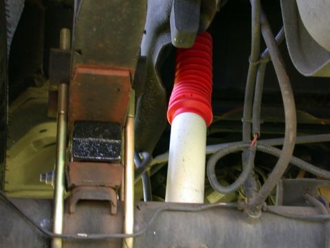 1996 Ford Bronco - Close-up of a vehicle's rear suspension shock absorber, showing the red protective boot.