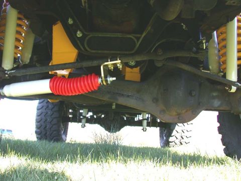 1996 Ford Bronco - The underside of a vehicle reveals its suspension components and drivetrain.