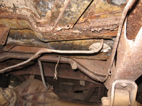 1983 Chevrolet Silverado 1500 - The undercarriage shows significant rust and deterioration, with various lines and components exposed.