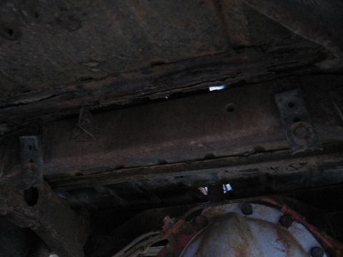 1983 Chevrolet Silverado 1500 - The underside of the vehicle shows significant rust and wear on the frame and suspension components.