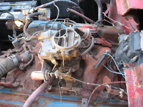 1983 Chevrolet Silverado 1500 - Close-up view of a rusty engine bay a carburetor and distributor.
