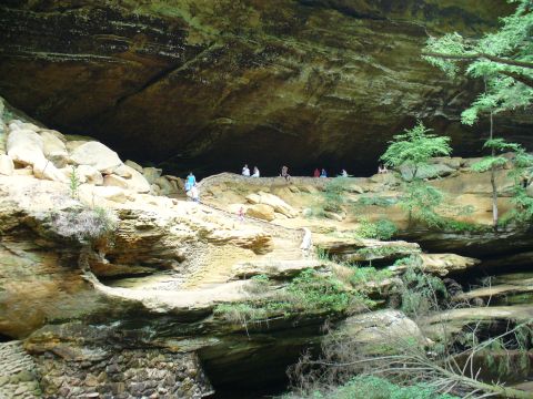 1991 Ford Probe - People explore a large cave overhang, with a Supermotors logo visible in the lower right corner of the image.