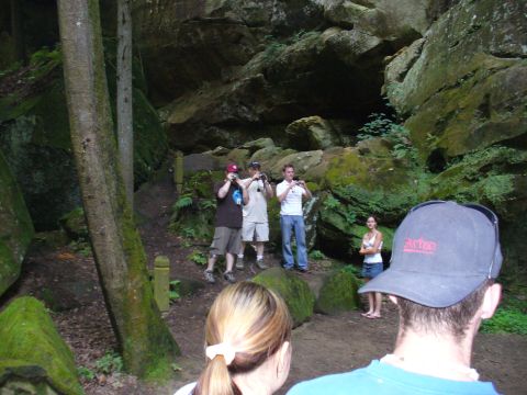 1991 Ford Probe - A group of people explore a natural landscape with large rock formations and dense foliage.
