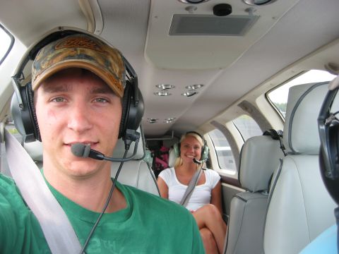 1989 Ford Bronco - Two passengers wearing headsets inside a small aircraft cabin.