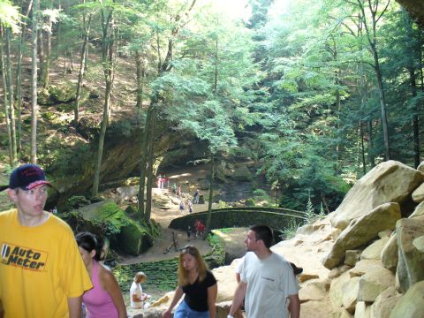 1991 Ford Probe - A group of people explore a scenic park with a stone bridge and lush greenery.