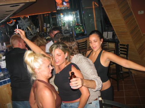 1989 Ford Bronco - A group of people are enjoying themselves at a lively bar, with drinks and music.