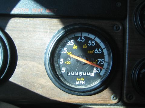 1990 Ford Bronco - black-faced MPH and km/h speedometer set in wood trim reads near 503500 on the odometer.