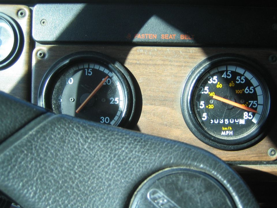Truck dashboard tachometer and speedometer with steering wheel in foreground